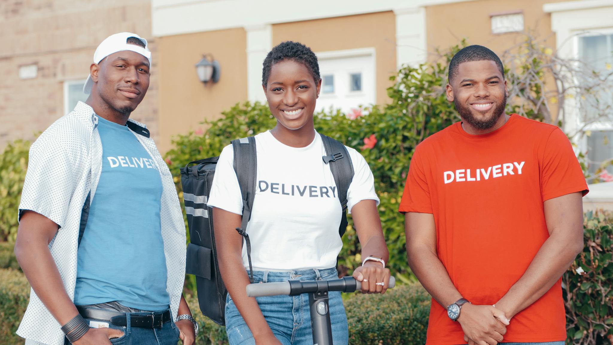 A diverse group of delivery workers smiling outdoors, showcasing teamwork and professionalism.